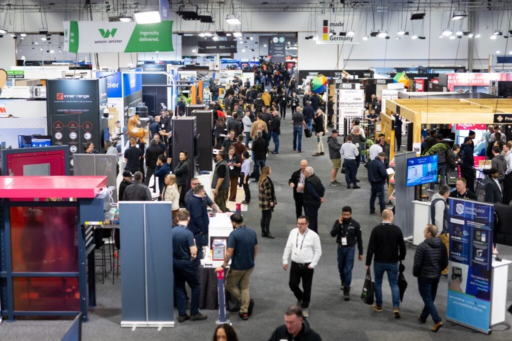 Crowded exhibition hall with technology and facilities management vendors showcasing products at the Facilities Integrate